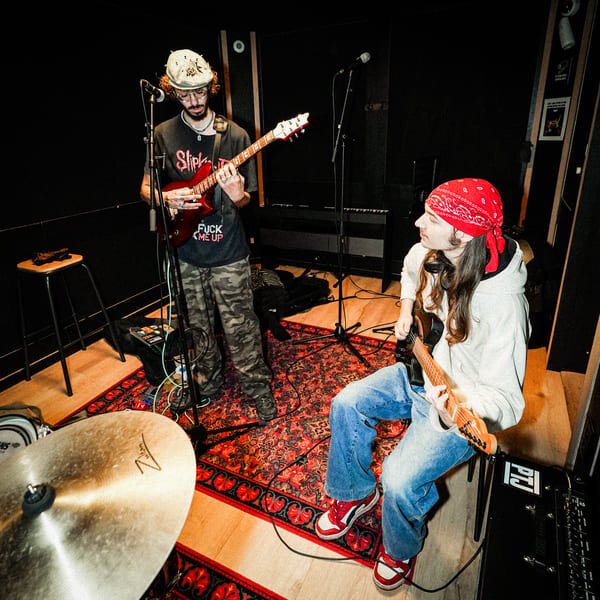 Gitarist en bassist in een repetitiestudio in luik