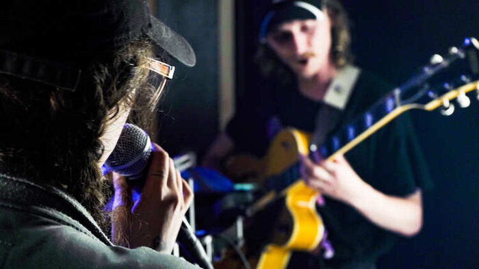 singer and guitarist playing in a rehearsal studio 