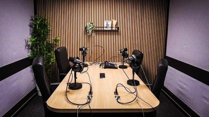 Podcast studio equipped with microphones, mixer and vintage decor