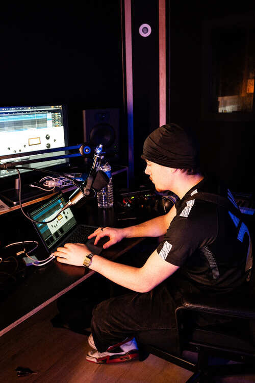 Young man producer and sound engineer in a recording studio