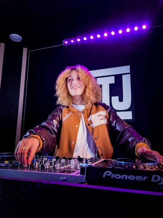 Lachende vrouw in DJ-studio aan het mixen op CDJ-3000's in luik