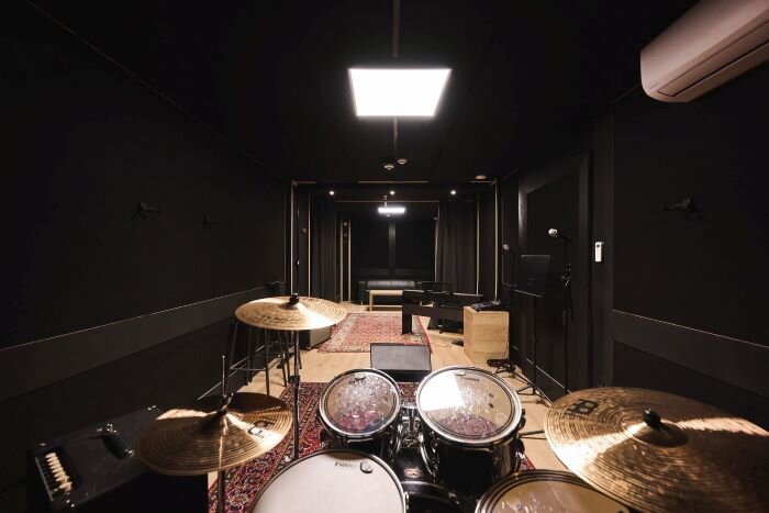 Repetitiestudio met drumstel, mengtafel en versterkers in luik