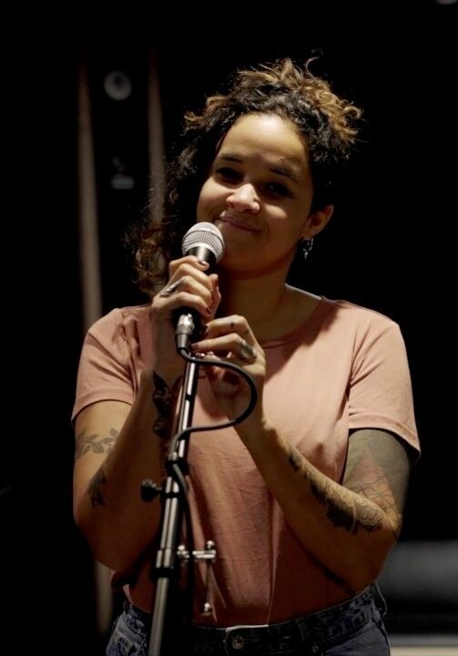 Female singer with singing microphone and standing in a rehearsal room. | © Plug The Jack