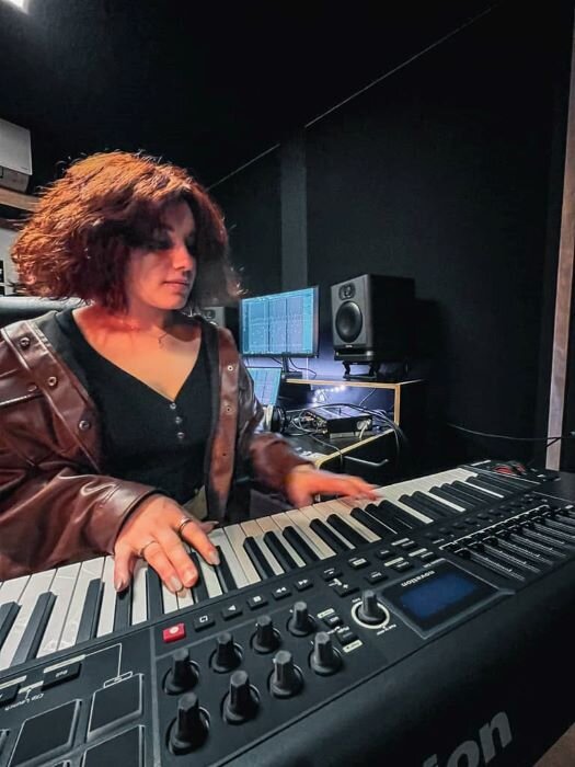 Pianist produceert muziek in opnamestudio met Novation master keyboard en audioproductiescherm. | © Plug The Jack