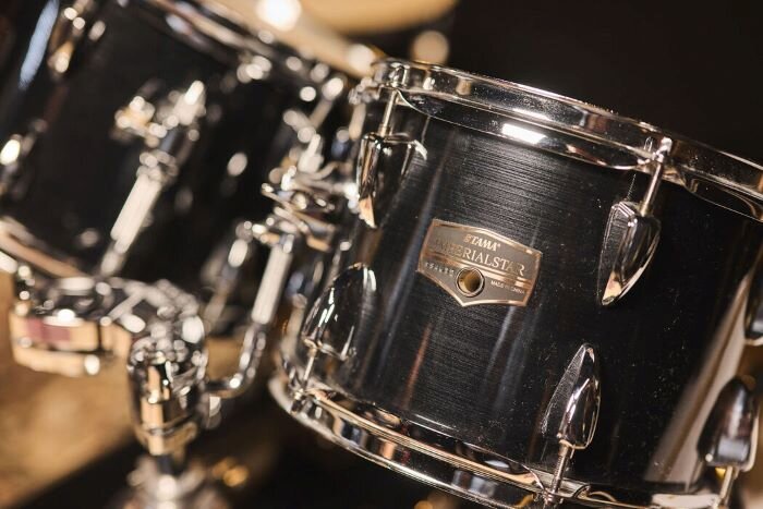 Toms van een Tama Imperial Star-drumstel in een repetitieruimte. | © Plug The Jack